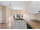 Well-lit kitchen with granite countertops, white cabinets, and modern appliances at 673 Leland Dr, Deltona, FL 32725