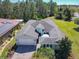 Expansive single-story home with a brick driveway, gray roof, and lush green landscaping at 759 Villa Park Rd, Poinciana, FL 34759