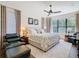 Spacious bedroom features a large bed, ceiling fan, windows and an area rug at 759 Villa Park Rd, Poinciana, FL 34759