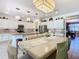 Bright dining area with a long table, pendant lights, and a view into the modern kitchen at 759 Villa Park Rd, Poinciana, FL 34759