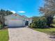 Charming home featuring a brick-paved driveway, manicured landscaping, and an attached garage for convenience at 759 Villa Park Rd, Poinciana, FL 34759