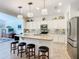 Bright kitchen with island seating, modern lighting, and stainless steel appliances at 759 Villa Park Rd, Poinciana, FL 34759