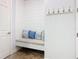 Cozy mudroom with a built-in bench, decorative pillows, coat hooks, and stylish shiplap accent wall at 759 Villa Park Rd, Poinciana, FL 34759