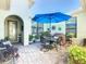 Charming patio with seating, plants, and a bright blue umbrella for relaxing outdoors at 759 Villa Park Rd, Poinciana, FL 34759