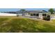 Backyard view featuring a screened-in pool and a spacious, well-maintained lawn at 7794 Indian Ridge S Trl, Kissimmee, FL 34747