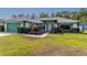 Charming single-story home with a manicured lawn and garden beds full of lush, colorful landscaping at 7794 Indian Ridge S Trl, Kissimmee, FL 34747