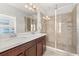 Bathroom featuring double sinks with a glass-enclosed shower with tile surround and chrome fixtures at 840 Luarca Ln, Oviedo, FL 32765