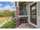 Inviting front porch with brick stairs, black railing, a cozy seating area, and a decorated front door at 840 Luarca Ln, Oviedo, FL 32765