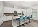 Modern kitchen featuring white cabinetry, quartz countertops, stainless appliances, and seating at the island at 840 Luarca Ln, Oviedo, FL 32765
