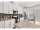Well-equipped kitchen with white cabinets, stainless appliances, a tiled backsplash, and a spacious island at 840 Luarca Ln, Oviedo, FL 32765