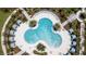 Aerial view of community pool with lush landscaping and lounge areas at 8968 Amelia Downs Trl, Kissimmee, FL 34747