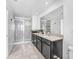 Modern bathroom featuring a double sink vanity, large mirror, and glass-enclosed shower at 8968 Amelia Downs Trl, Kissimmee, FL 34747
