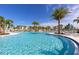 Expansive community pool with lounge areas and palm trees at 8968 Amelia Downs Trl, Kissimmee, FL 34747