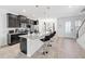 Modern kitchen features dark wood cabinets, stainless appliances, and an island with bar seating at 8968 Amelia Downs Trl, Kissimmee, FL 34747