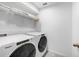Bright laundry room with modern machines, shelving, and ample storage at 8968 Amelia Downs Trl, Kissimmee, FL 34747