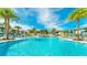 Beautiful community pool with palm trees and clear blue water at 8968 Amelia Downs Trl, Kissimmee, FL 34747
