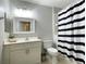 Bathroom featuring a shower with a striped curtain, a toilet, and a sink with cabinet storage at 910 Spring Park St # 103, Celebration, FL 34747