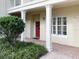 Charming condo entrance with a welcoming red door, brick pavers, and well-maintained landscaping at 910 Spring Park St # 103, Celebration, FL 34747