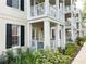 Building exterior showcasing balconies, black shutters, well-maintained landscaping, and architectural details at 910 Spring Park St # 103, Celebration, FL 34747