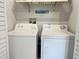 Laundry room with a white washer and dryer, plus shelving for storage and organization at 910 Spring Park St # 103, Celebration, FL 34747