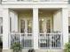 Charming patio with striped seating, a ceiling fan, and elegant white pillars for outdoor relaxation at 910 Spring Park St # 103, Celebration, FL 34747
