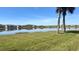 Scenic lake view featuring green grass, blue skies, and beautiful landscaping at 13840 Timberbrooke Dr # 103, Orlando, FL 32824