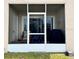 Screened-in patio with seating, sliding glass doors, and exterior door at 13840 Timberbrooke Dr # 103, Orlando, FL 32824