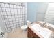 Well-lit bathroom with a toilet, sink, and shower with a checkered curtain at 1061 Citrus Landings Blvd, Davenport, FL 33837