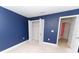 The spacious bedroom has navy blue walls and an open closet for ample storage space at 1061 Citrus Landings Blvd, Davenport, FL 33837