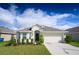 Charming single-story home with a well-kept lawn, two-car garage, and manicured landscaping at 1061 Citrus Landings Blvd, Davenport, FL 33837