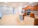 An open-concept kitchen features stainless steel appliances, wooden cabinets, an island, and a tile floor at 1061 Citrus Landings Blvd, Davenport, FL 33837