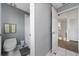 Bathroom with white tile floor, gray walls, and a toilet with a shower behind the door at 10937 Prairie Hawk Dr, Orlando, FL 32837