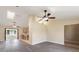 Open-concept living area with wood-look floors, ceiling fans, and a view into kitchen at 1127 Anne Elisa Cir, St Cloud, FL 34772