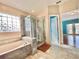 Elegant bathroom featuring a marble tub, glass shower and natural light at 12450 Greco Dr, Orlando, FL 32824