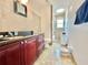 Bathroom featuring dark cabinets, marble floors and granite countertop at 12450 Greco Dr, Orlando, FL 32824