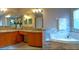 This bathroom features a soaking tub, granite countertop, and double sinks with vanity and mirror at 152 Moscato Dr, Davenport, FL 33897