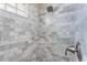 Shower stall featuring gray and white marble tile and glass block window at 152 Moscato Dr, Davenport, FL 33897