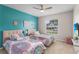 Twin beds in a colorful bedroom with a bright aqua accent wall and modern decor at 152 Moscato Dr, Davenport, FL 33897