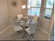 Cozy dining area with round glass table, four chairs, and a decorative chandelier at 152 Moscato Dr, Davenport, FL 33897