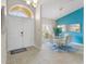 Bright dining room with modern glass table set, accented by an elegant light fixture and tiled floors at 152 Moscato Dr, Davenport, FL 33897