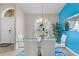 Dining room showcasing modern glass table set and a pop of color from the blue accent wall at 152 Moscato Dr, Davenport, FL 33897