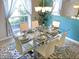 Bright dining room features a glass table, seating for six, modern lighting, and stylish decor at 152 Moscato Dr, Davenport, FL 33897