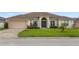 Charming single-story home featuring a well-manicured lawn and a two-car garage at 152 Moscato Dr, Davenport, FL 33897