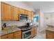 Close-up of the kitchen area with stainless steel appliances and wooden cabinetry at 152 Moscato Dr, Davenport, FL 33897