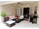 An outdoor patio features comfortable seating, a grill, and tasteful lighting with a view into the house at 152 Moscato Dr, Davenport, FL 33897