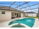 Inviting in-ground pool and spa area with a screened-in enclosure and ample patio space at 152 Moscato Dr, Davenport, FL 33897