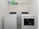 A laundry room with white appliances, wire shelving, and tile flooring at 1536 Mirabella Cir, Davenport, FL 33897