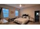 Cozy bedroom with white furniture, ceiling fan, and natural light from two bright windows at 17880 Passionflower Cir, Clermont, FL 34714