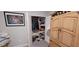 Small closet with clothing and assorted items, next to the gray wall, wooden armoire, and painting at 17880 Passionflower Cir, Clermont, FL 34714