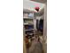 Organized closet with built-in shelving, packed with a diverse selection of clothing and household items at 17880 Passionflower Cir, Clermont, FL 34714